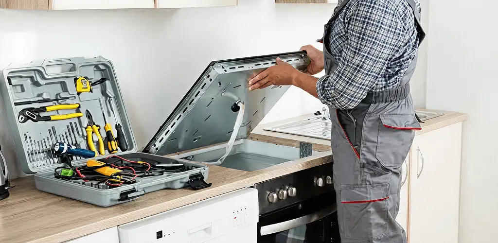 Handyman repairing a cooktop and checking wiring connections in Albany, NY