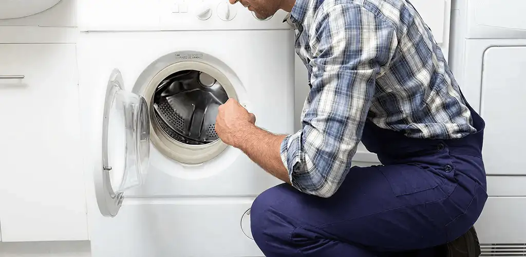 Handyman inspecting a dryer drum and internal parts for repair in Albany, NY