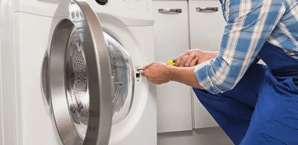 Handyman repairing a clothes dryer and checking electrical connections in Albany, NY