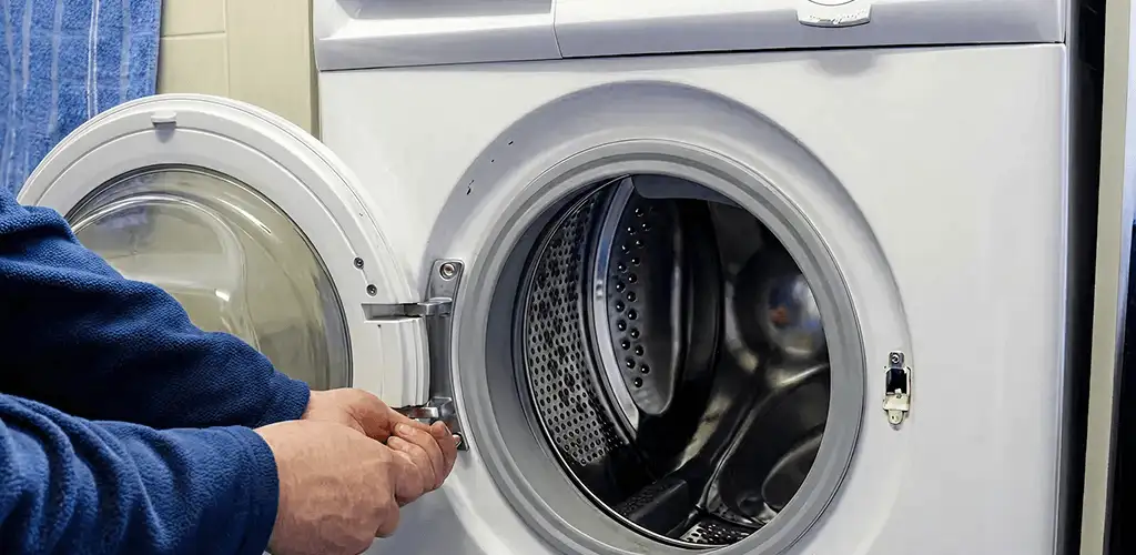 Washing machine repair handyman checking a front-load washer door and latch in Albany, NY
