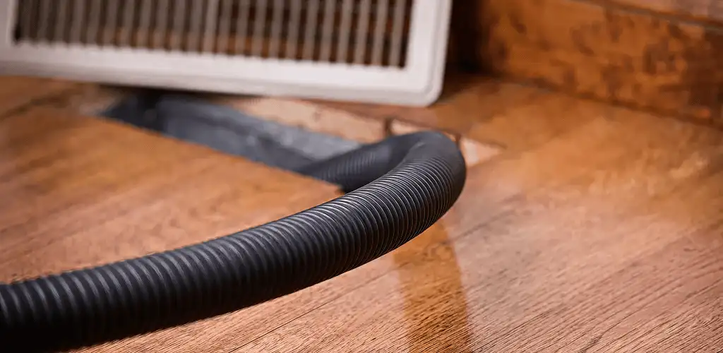 Air duct cleaning hose inserted into a floor vent for ductwork cleaning in Albany, NY
